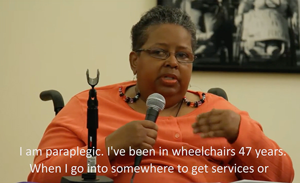 a woman in a wheelchair speaking into a microphone
